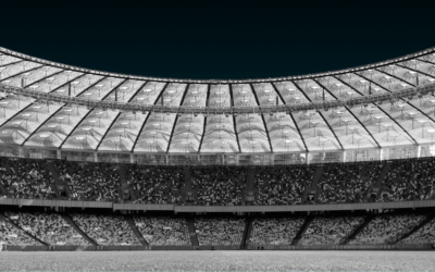 Stade de football rempli de spectateurs sous un toit incurvé, ambiance Coupe du Monde, illustration de l'article G-OPS sur le prono d'équipe